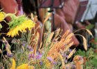 Sonnenblumen und Getreide schmücken die Bühne bei der Freisprechungsfeier auf der im Hintergrund Musikanten spielen.
